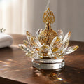 Gold crystal-style lotus incense burner on a wooden table