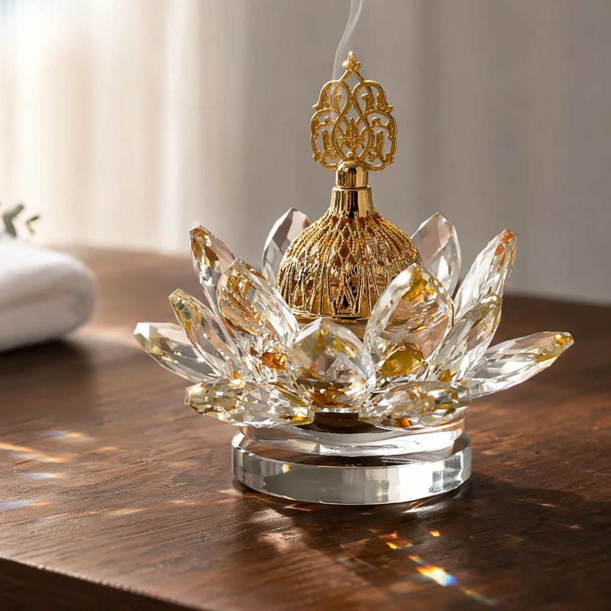 Gold crystal-style lotus incense burner on a wooden table