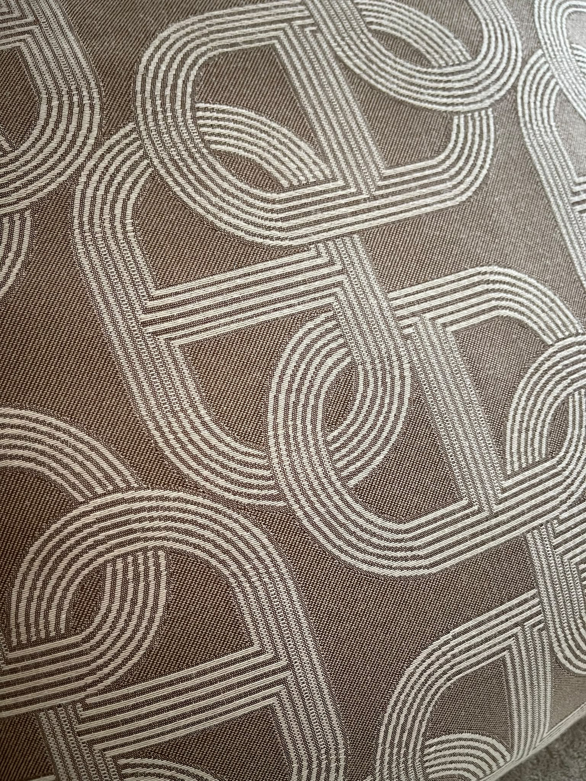 Close-up of the beige cushion's interlocking chain pattern