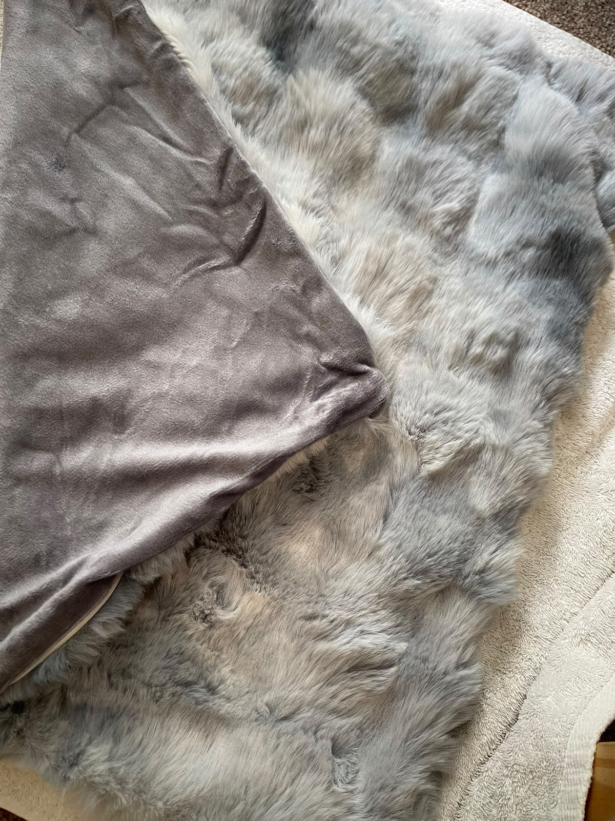 Close-up of blue grey fur-effect cushion texture and contrasting reverse