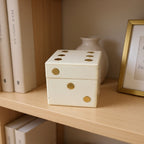 Ivory and gold dice box open on mantelpiece showing dice inside