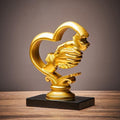 Gold holding hands heart sculpture - full view on wooden surface showing complete piece