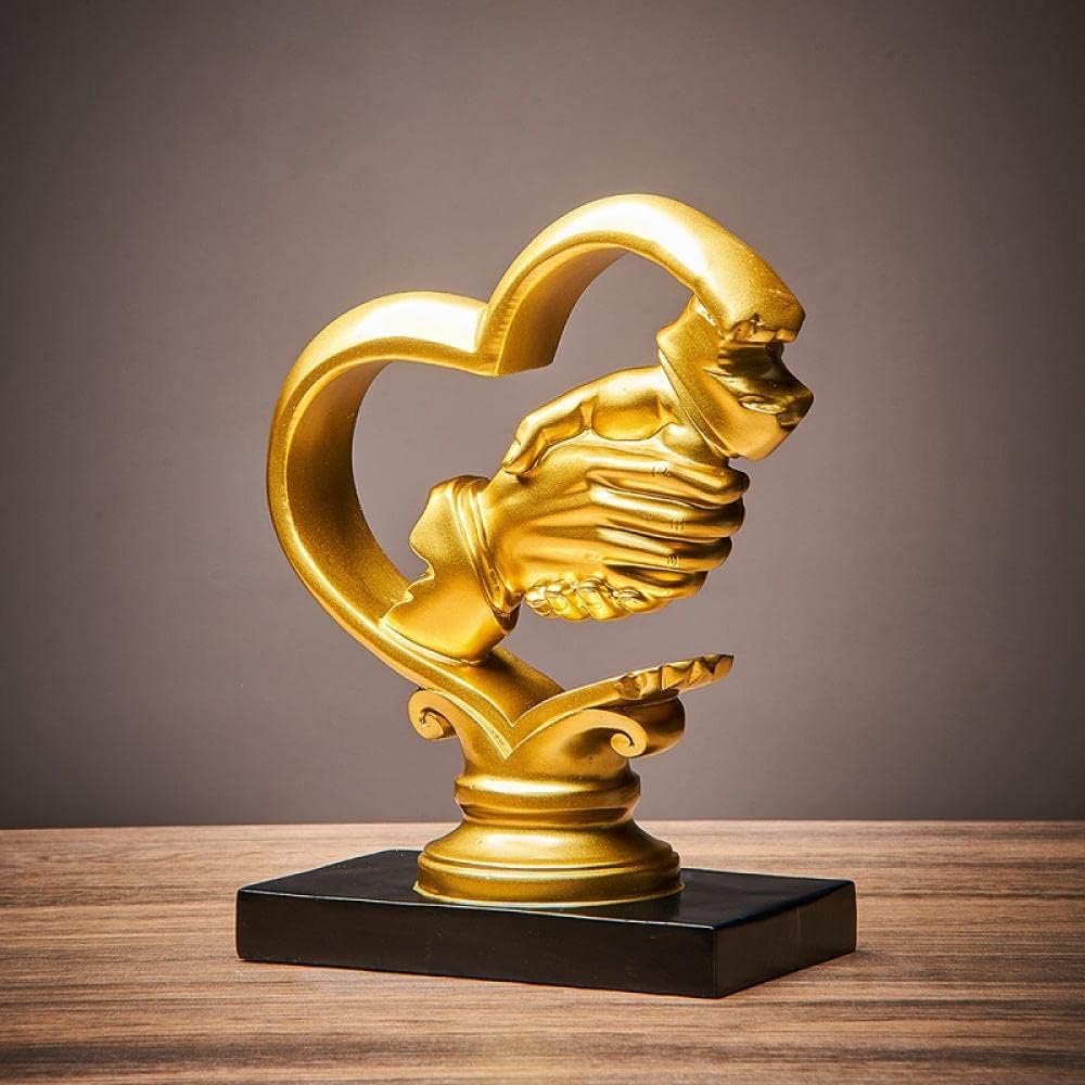 Gold holding hands heart sculpture - full view on wooden surface showing complete piece