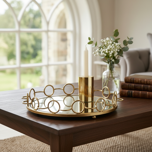 Gold ring tray on coffee table with white flowers and gold candle holder