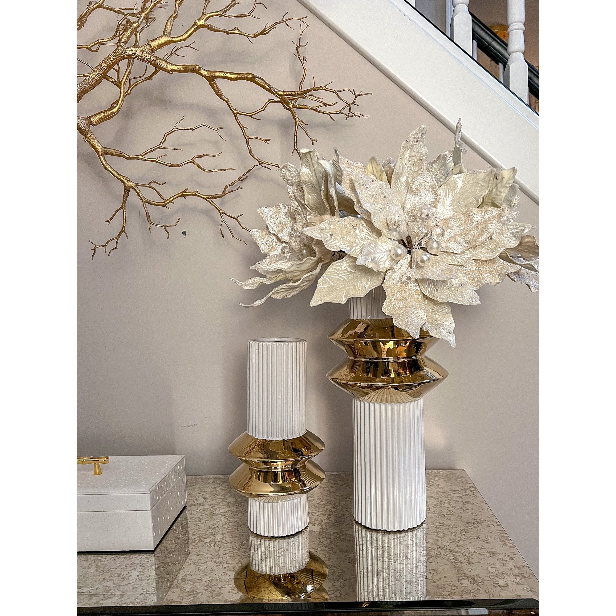 Ribbed white and gold vases styled with white florals on a console table