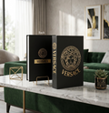 Versace decorative coffee table book matte black cover with gold Medusa medallion – front and back view on marble table in luxury living room with green velvet sofa